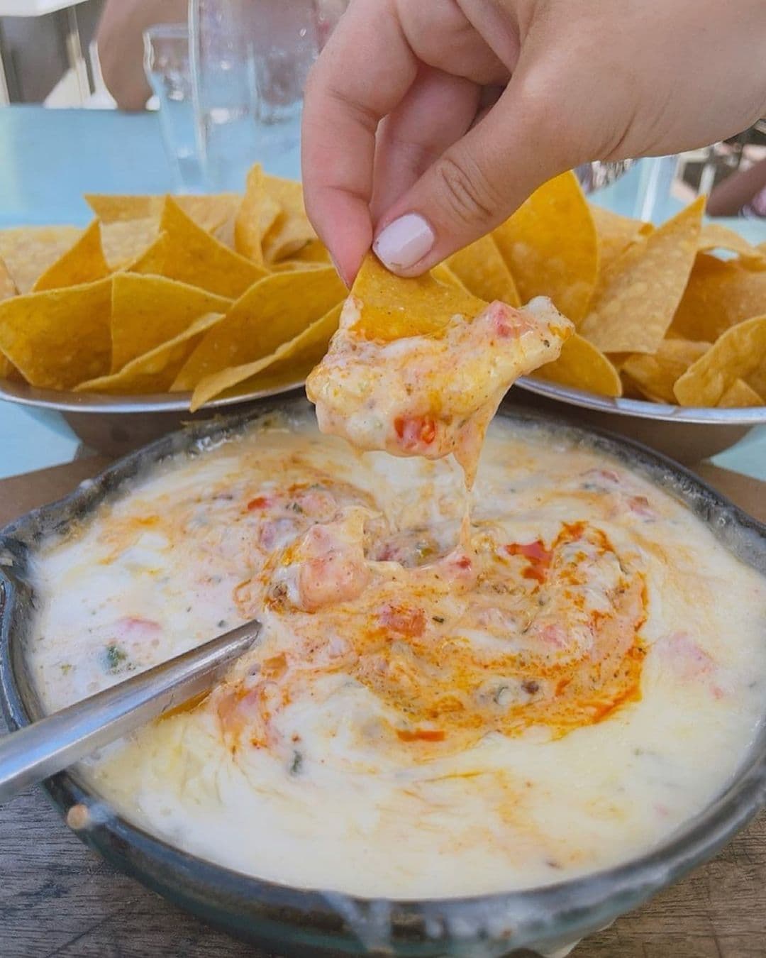 Chip dipped in bowl of queso