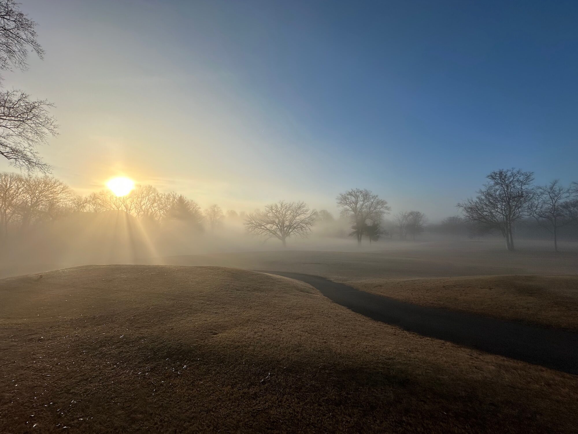 A foggy golf course and sunrise