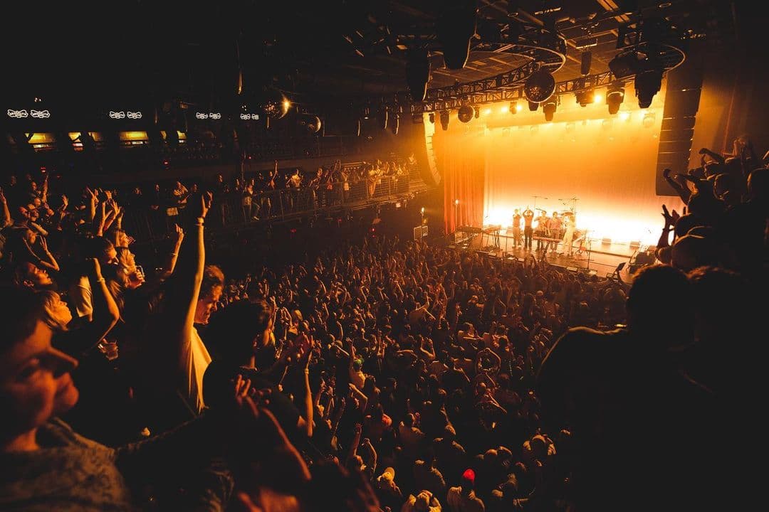 A crowd cheers a band on at Brooklyn Bowl