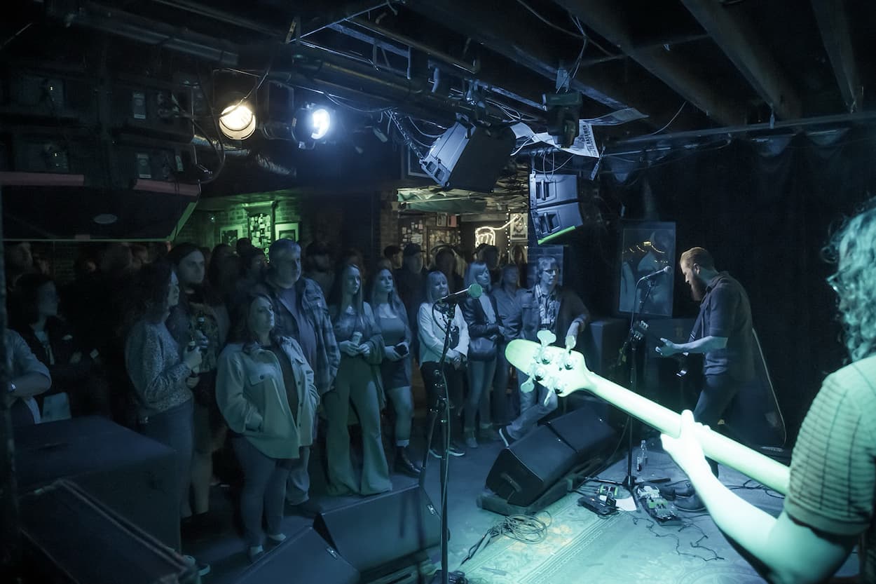Concert goers watch a band at The Basement