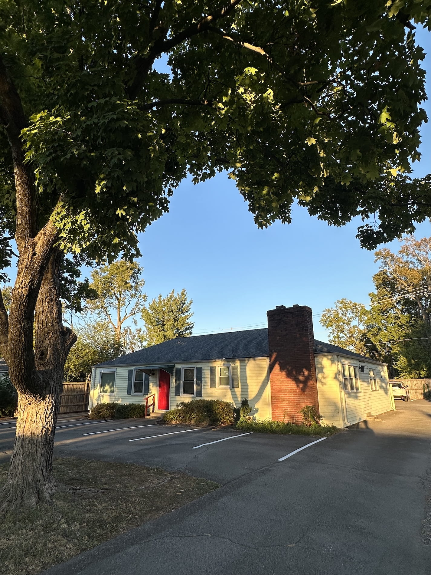 A Berry Hill office with a red door and a big tree
