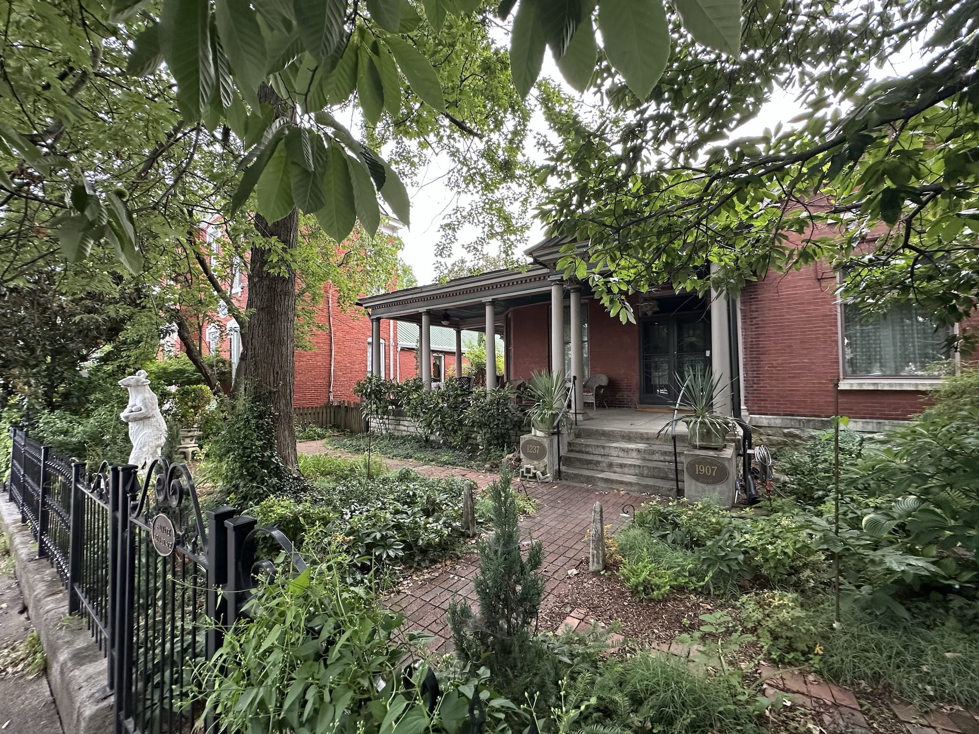 An old brick house with overgrown greenery