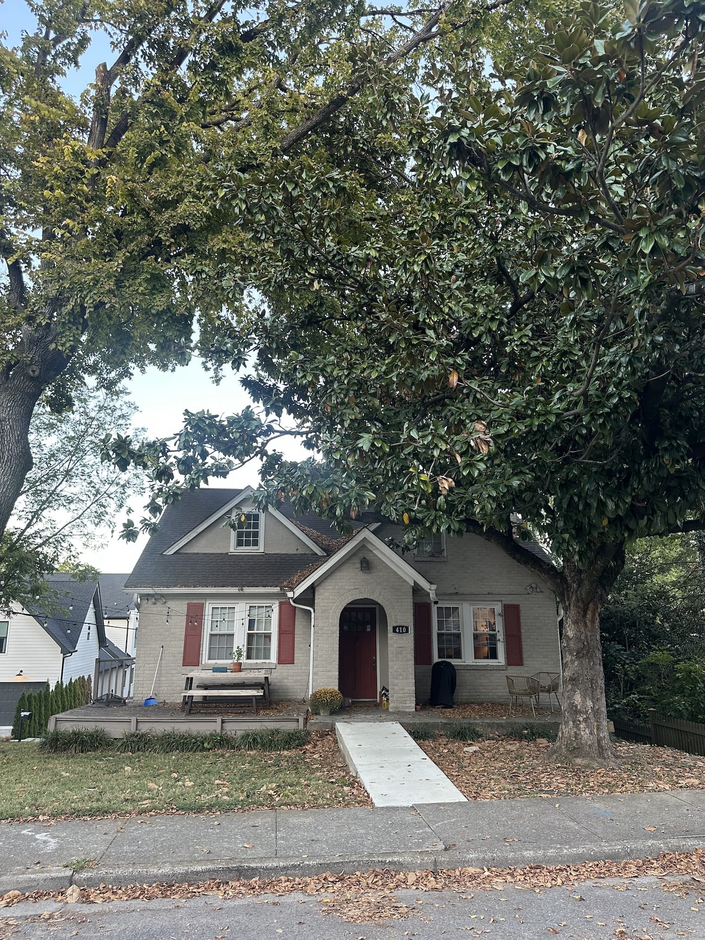 A small house with big trees in the yard