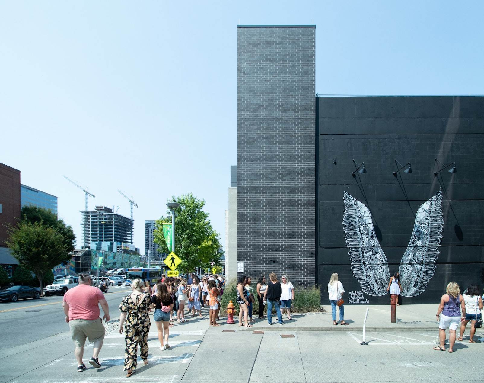 People in line by wings mural