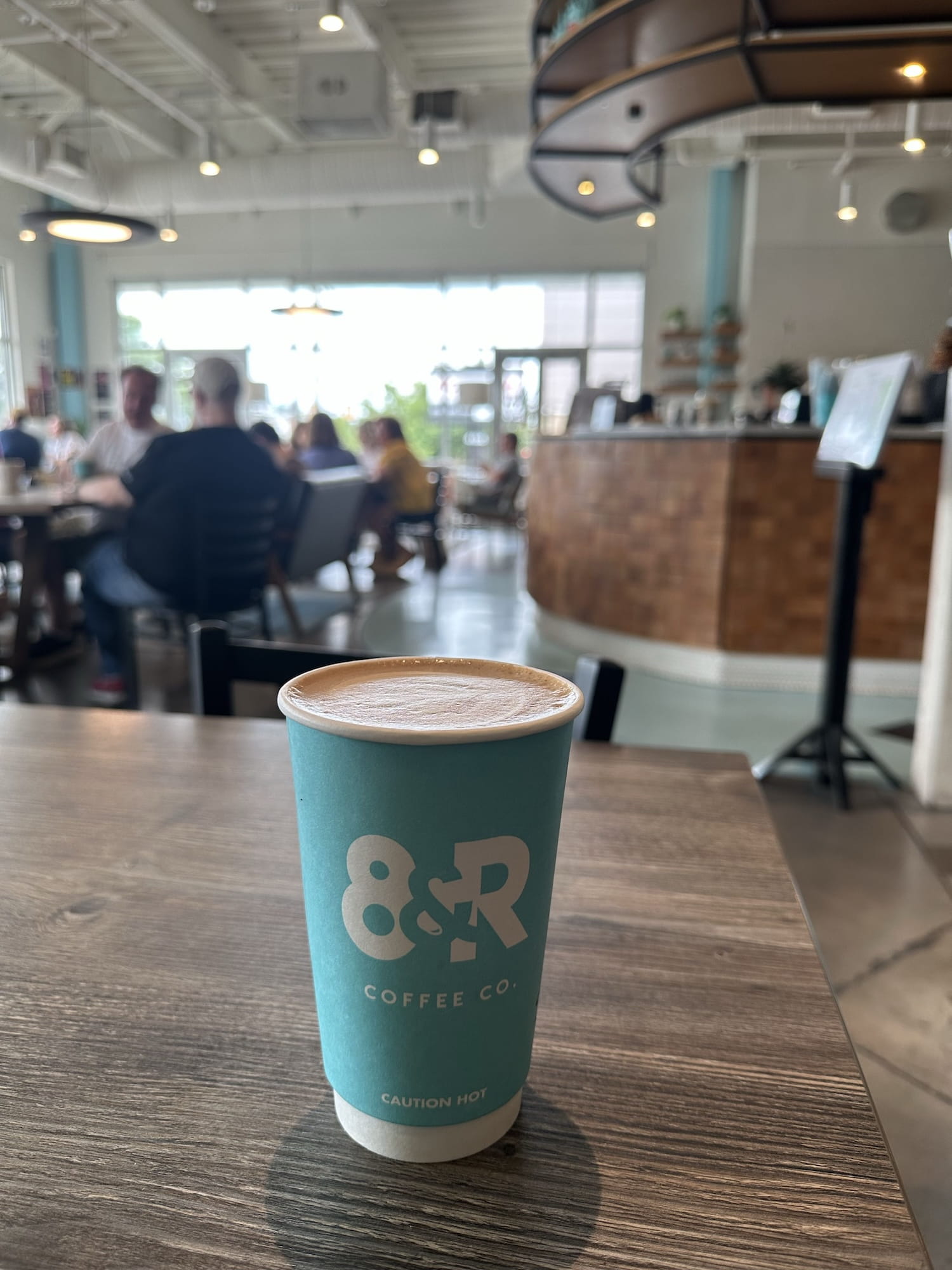 A latte on a table inside 8th and Roast West