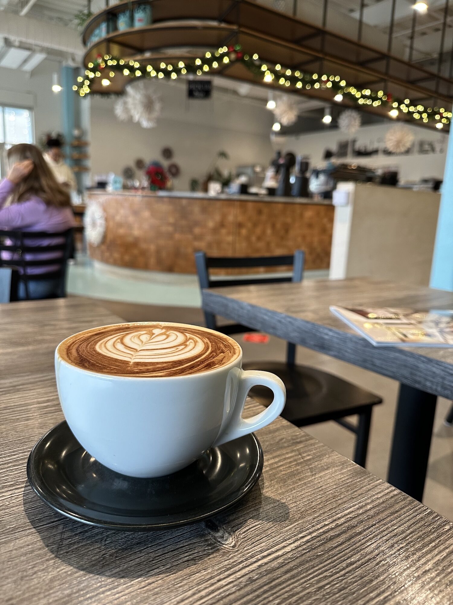 A capuccino and Christmas lights in a coffee shop