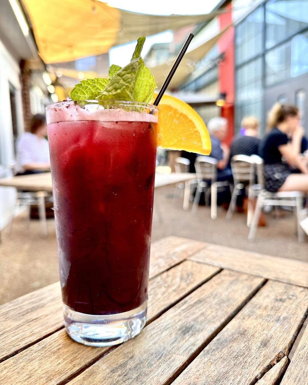 A drink on a table next to a painted wall