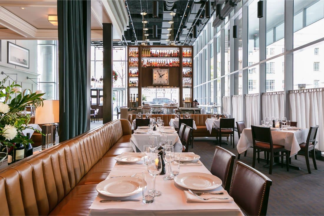 A booth and a large clock at a nice restaurant