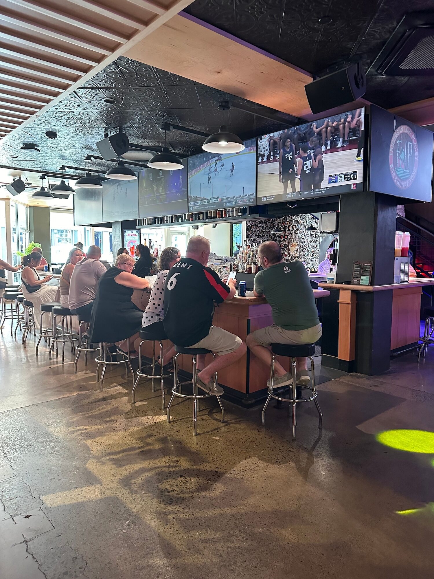 People sitting at a bar with TVs