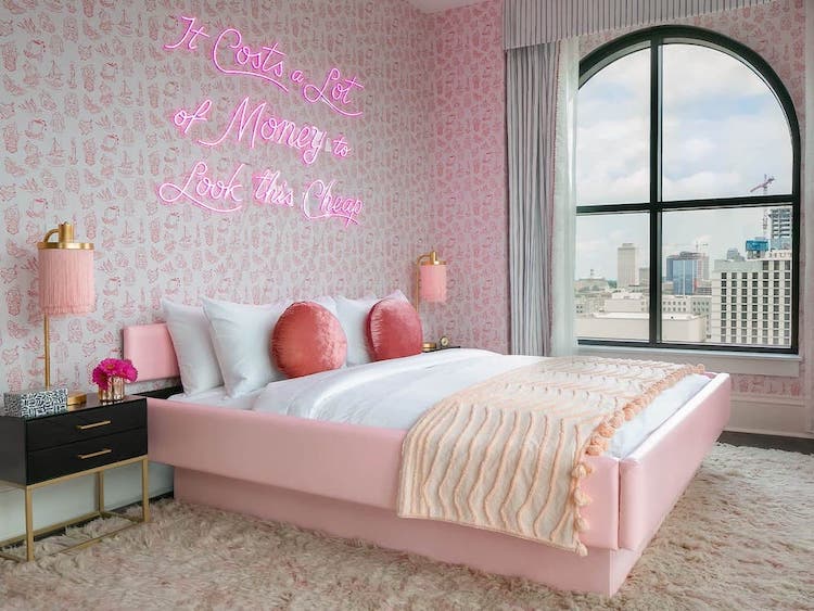 A pink bedroom with a funny sign