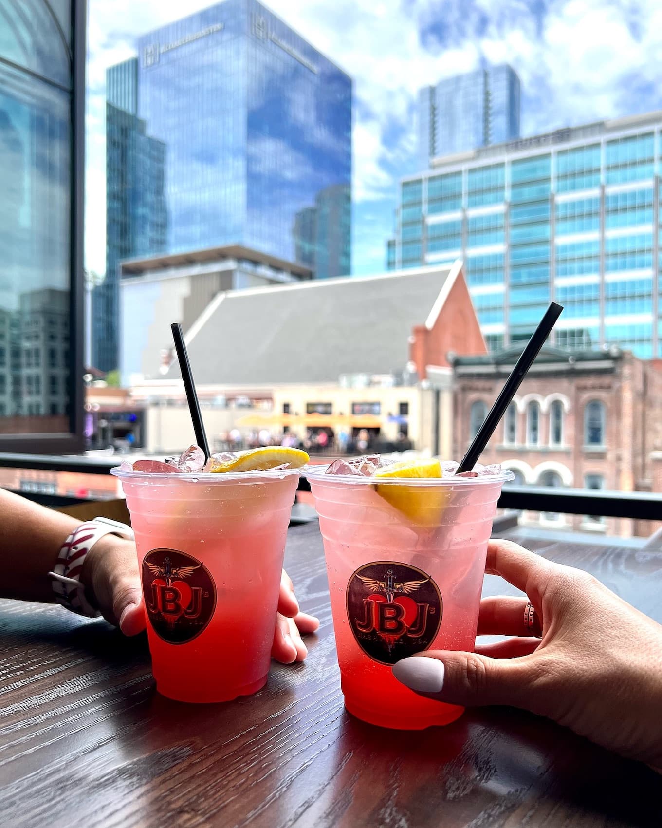 Two colorful drinks on a rooftop bar