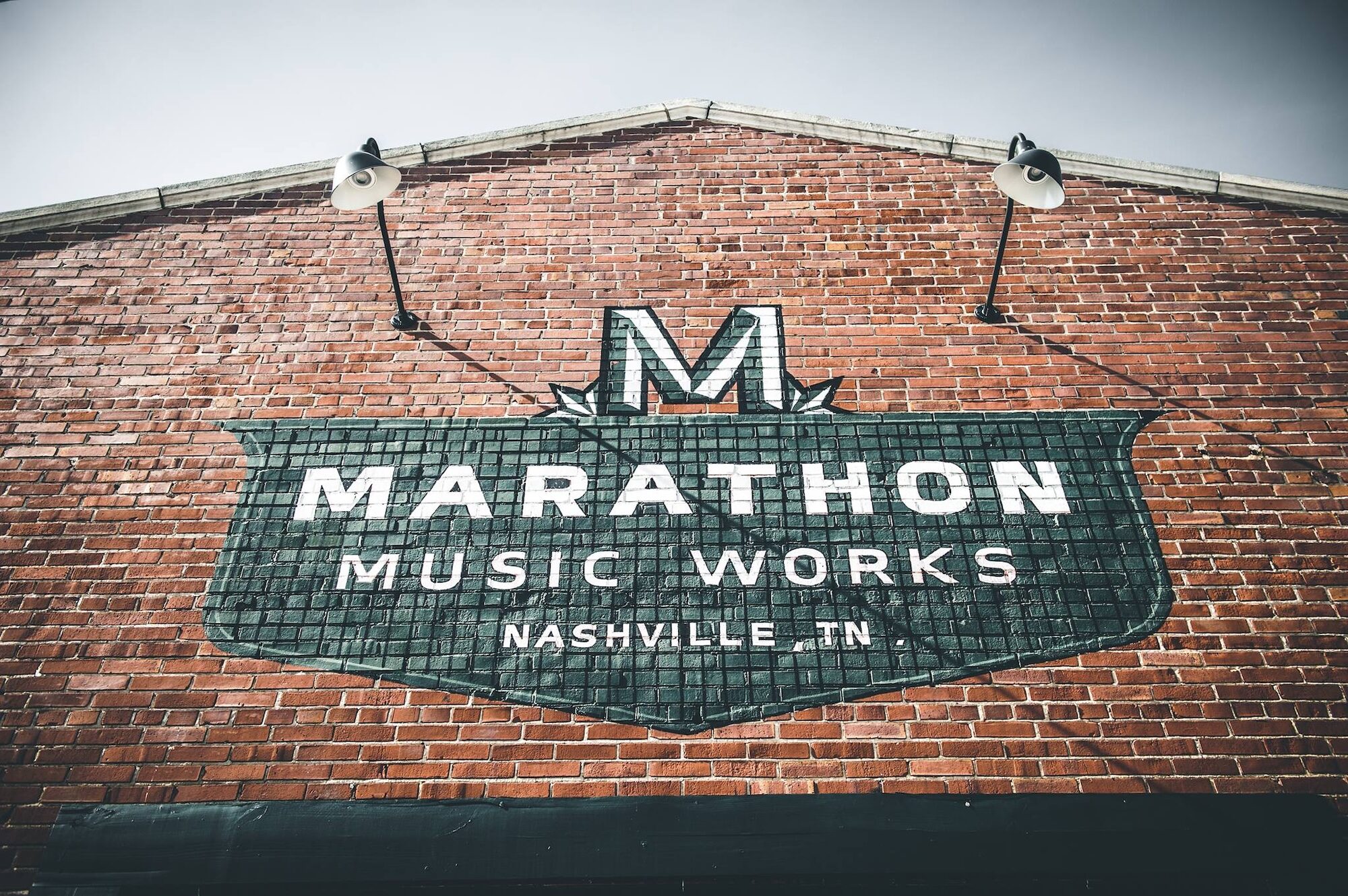 Marathon Music Works logo on red brick