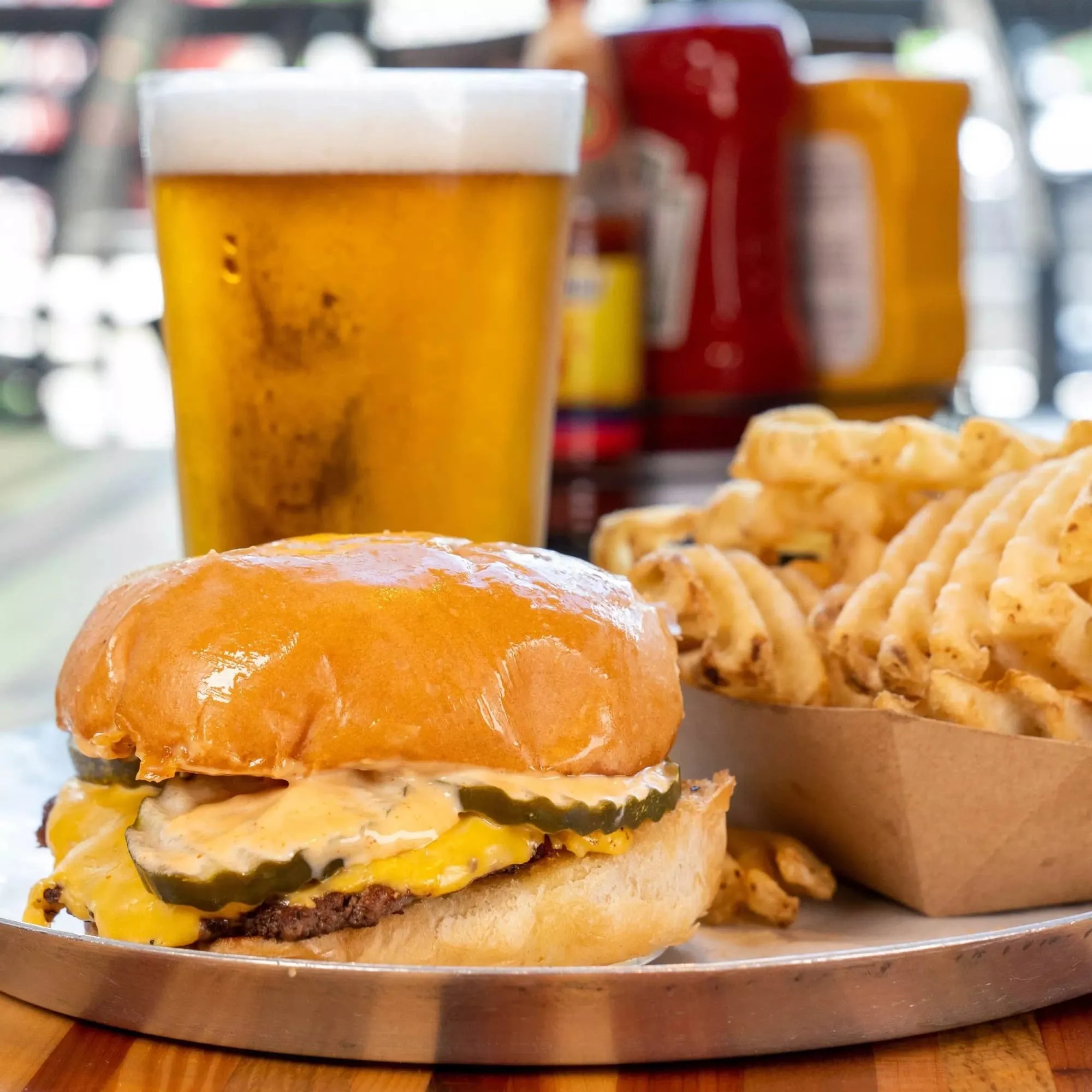 A cheeseburger with fries and a beer