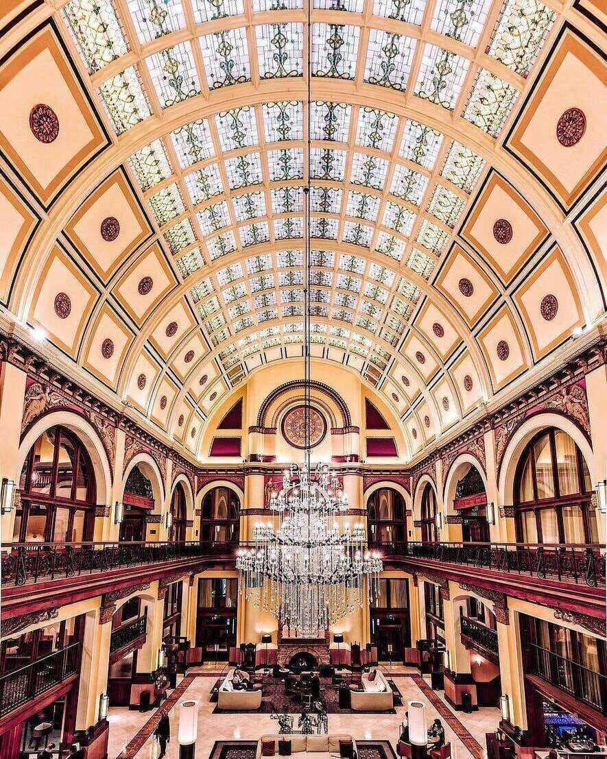 A beautiful chandelier and ceiling in an old hotel